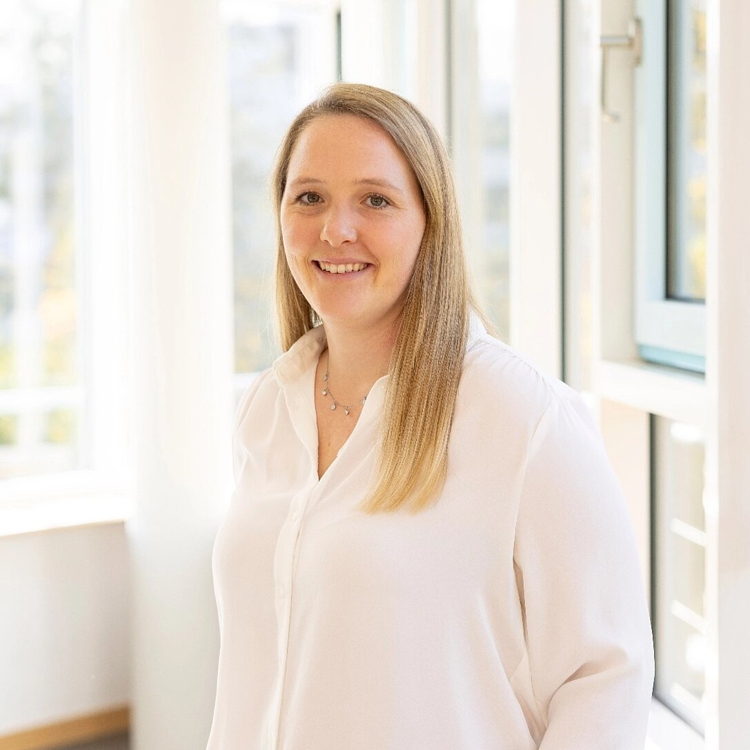 IPC-Löttrainerin Lisa Greck steht vor einer Fensterfront